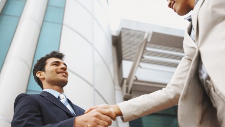 Low angle view of two business executives shaking hands